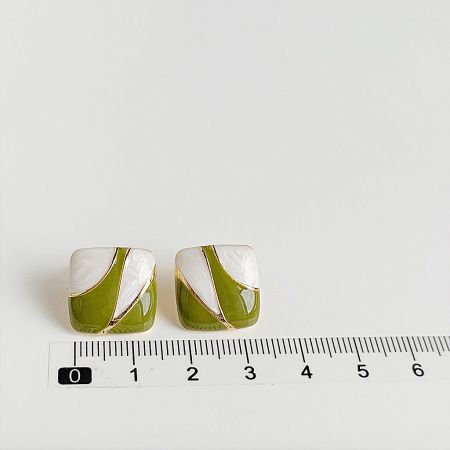 Earrings shown next to a ruler to indicate their size.