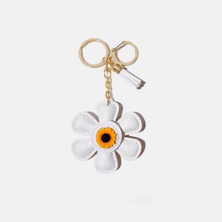 Elegant white leather sunflower keychain with gold accents.
