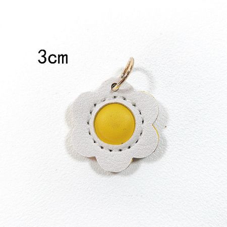 A white flower PU leather charm with a yellow center