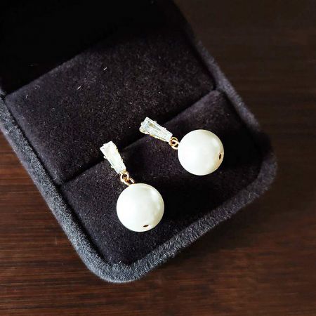 The set of French fashion pearl earrings presented in a classic black jewelry box.
