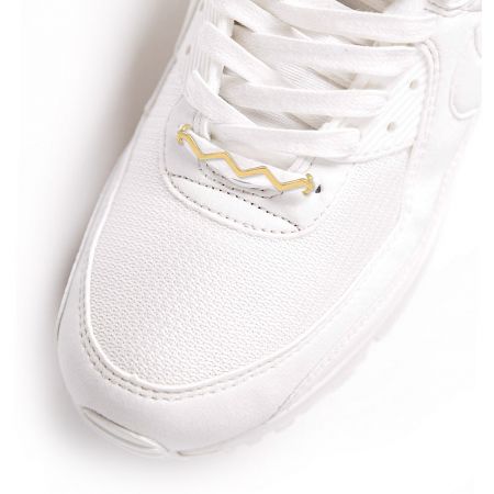 The wave shoelace charm elegantly accessorizing a pair of white sneakers, demonstrating its stylish application.