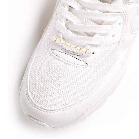 Pearl Shoe Charm - Close-up of a stylish Pearl Shoe Charm with gold plating and white pearls adorning the laces of a white sneaker.