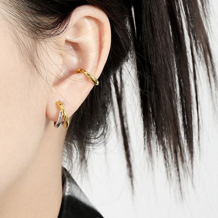 A close-up model shot of the two-tone knot hoop earrings being worn, highlighting their minimalist chic style.