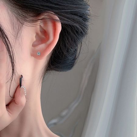 A model wearing the dainty flower rose stud earrings to showcase their size and style.