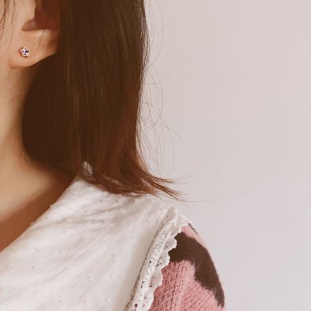 Lifestyle image of a model wearing the star stud earrings as part of a chic outfit.