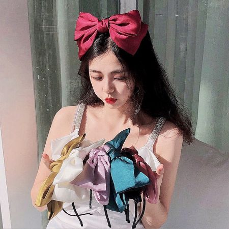 Vintage Big Bowknot Girls Hairband Headbands (5 pcs) - A woman's hands holding a vibrant collection of vintage-style big bowknot hairbands for girls, available in multiple colors.