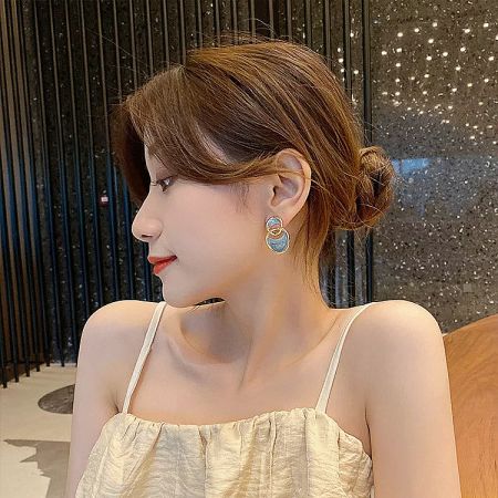 Model wearing the 14k gold plated blue enamel stud earrings.