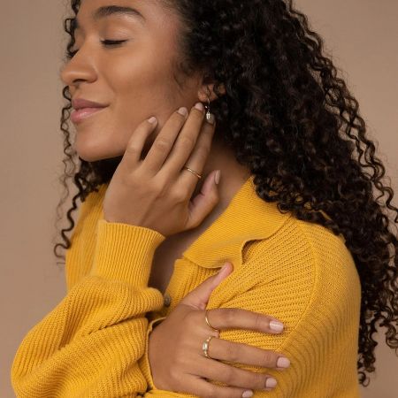 Close-up of a woman wearing multiple stackable gold-plated baguette CZ rings for a minimalist look.