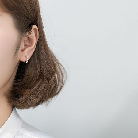 A model showcasing the elegant 925 sterling silver twist hoop earrings, highlighting their size and fit.