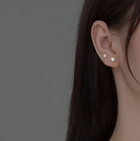 A model showcasing the elegant 925 Sterling Silver Halo Stud Earrings, highlighting their appearance when worn.