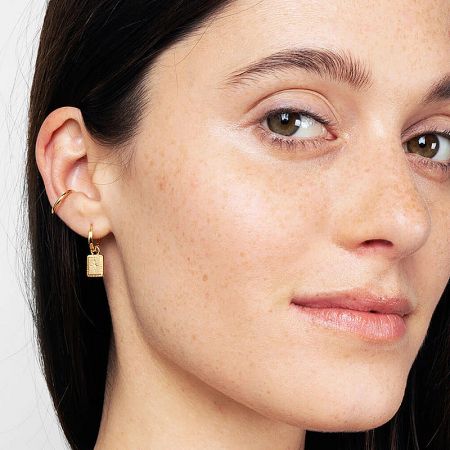 Lifestyle image showcasing a woman wearing the gold celestial dangle earrings.