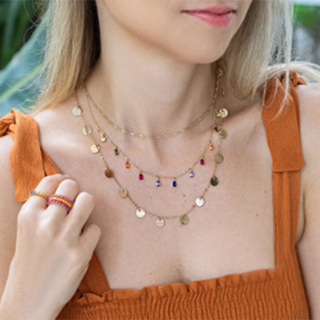Model wearing the 925 sterling silver rainbow teardrop necklace, layered with other gold jewelry.