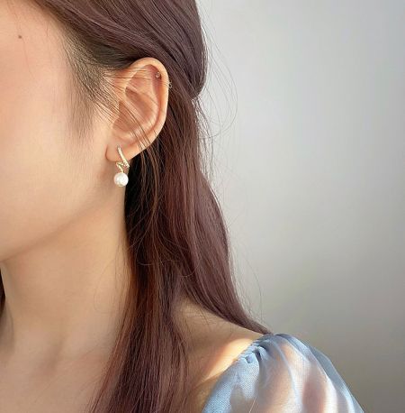 Model showcasing the elegant 925 Sterling Silver Pearl Twisted Earring, highlighting its size and appearance when worn.