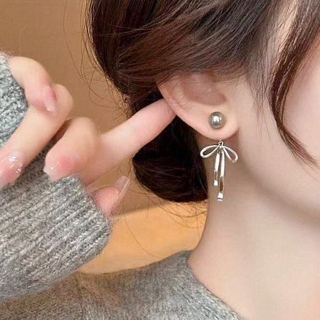 Model wearing the grey pearl and silver bow drop earrings.