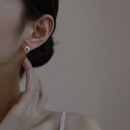 Model showcasing the elegant 925 sterling silver rhombus stud earrings with aquamarine CZ.