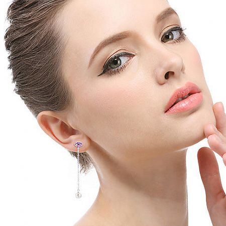 Model showcasing the elegant drape of the purple gemstone and pearl tassel earrings.