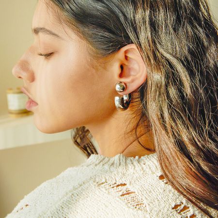 Model showcasing the elegant look of the silver chunky ball stud earrings.