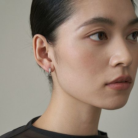 Model showcasing the elegant quilted hoop earrings, highlighting their shine and fit.