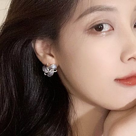 A model showcasing a pair of delicate silver flower-design stud earrings from the set.