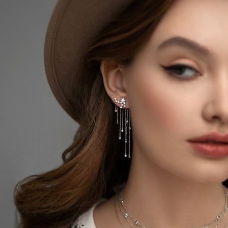 Lifestyle image of a woman wearing the dainty silver CZ star tassel earrings, perfect for festive gifting.