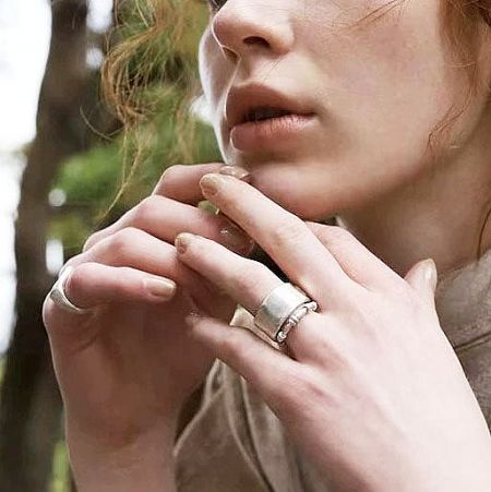 Detailed shot of the silver two-layered ring on a woman's finger.