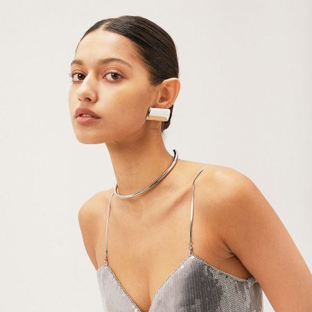 A stylish model showcasing the silver rectangular earrings as part of a complete fashion look.