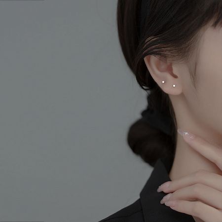 Model wearing the tiny circle stud earrings, showcasing their subtle and stylish look.