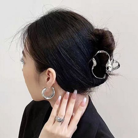 Close-up of a silver cloud-shaped wave hair clip in a woman's hair.