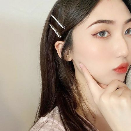 Close-up of a model wearing a silver rhinestone hair clip, highlighting its sparkle and detail.