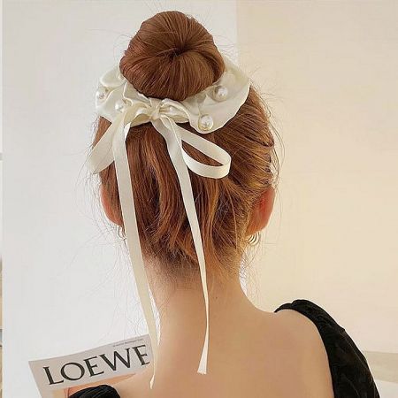 A model showcasing how to style the white ribbon hair bow for a chic and fashionable look.