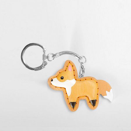 Detailed close-up of a hand-carved wooden fox keychain with PU leather accents.