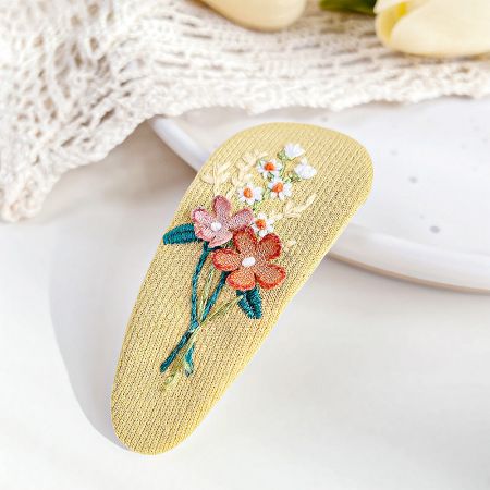 The yellow version of the embroidered floral hair snap clip.
