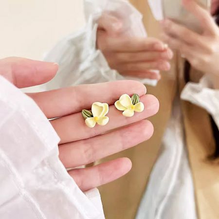 Another view of the pair of yellow flower stud earrings.