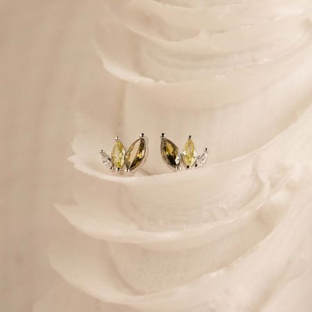 Dainty S925 sterling silver marquise earrings with yellow gemstones resting on a textured white surface.