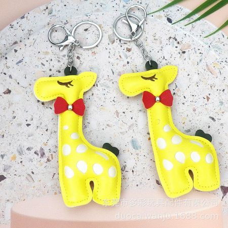 A pair of yellow giraffe keychains with white polka dots and cute red bows.