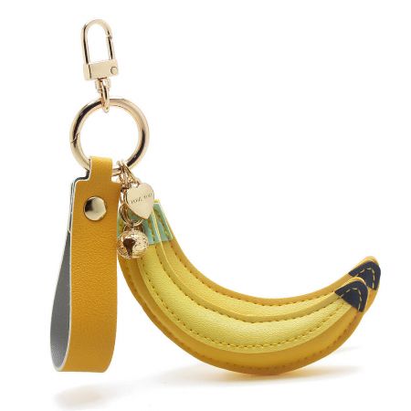 A detailed view of the single banana PU leather keychain with its sturdy gold clip and charm.