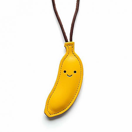 Fun yellow leather banana pendant with a smiling face, a playful custom accessory.