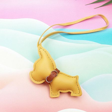 A cheerful yellow leather dog-shaped keychain with a matching strap.
