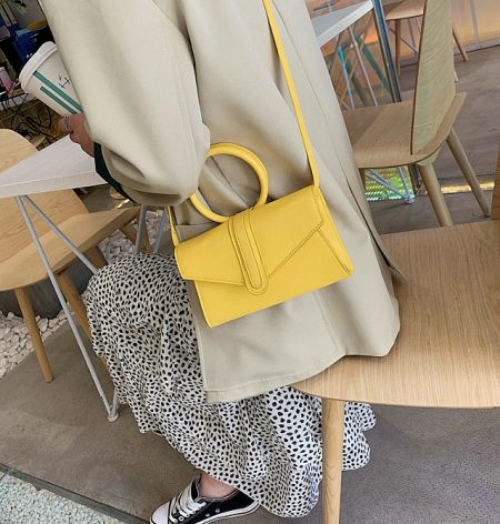 Close-up of the yellow version of the PU leather shoulder bag, highlighting its texture and color.