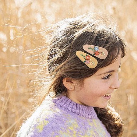 Young girl wearing the charming floral embroidered hair clips in her hair.