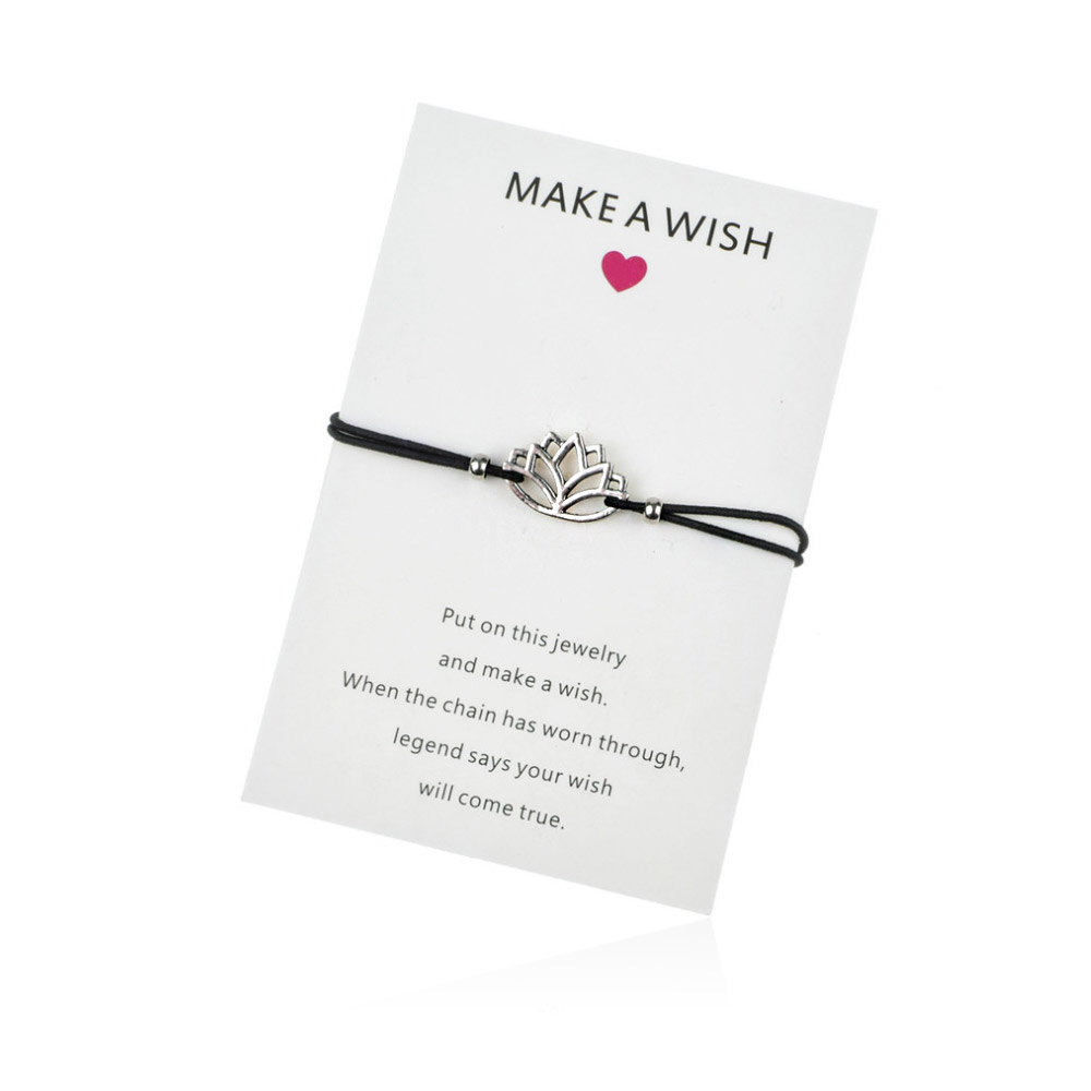 A close-up of the Lotus Cord Bracelet featuring a black waxed cord and a silver lotus flower charm, presented with a 'Make A Wish' card.
