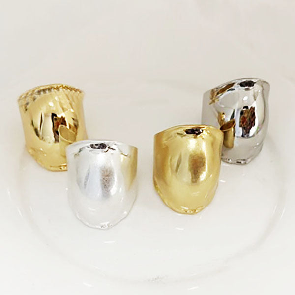 A set of brass vintage drum-shaped curved rings in polished gold and silver finishes.