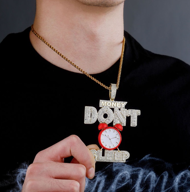 Custom 'Money Don't Sleep' hip hop necklace pendant featuring an alarm clock design, crafted in gold-plated metal with sparkling stones.