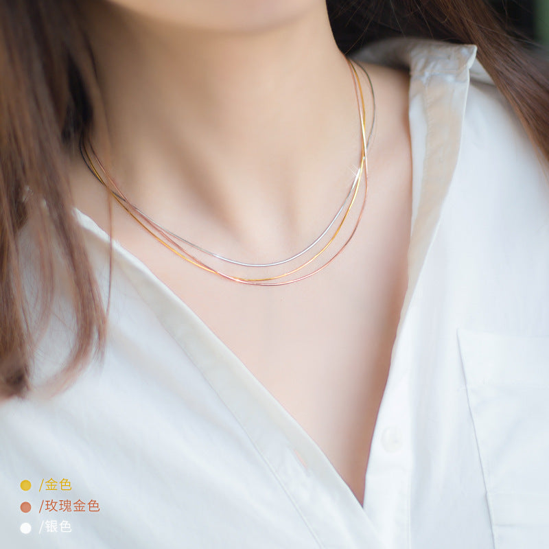 Model wearing the 925 sterling silver snake chain necklace set, showcasing the layered look with gold, rose gold, and silver tones.
