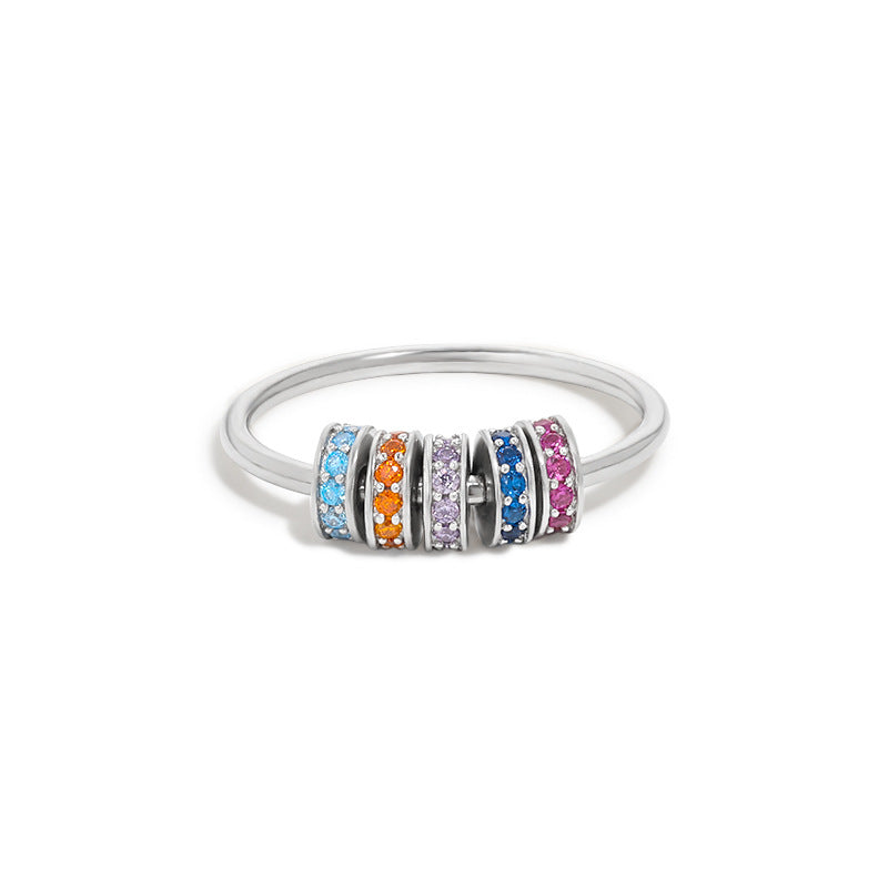 A close-up of the 925 sterling silver ring featuring a row of vibrant, multi-colored rotating zircon beads, showcasing its unique design.