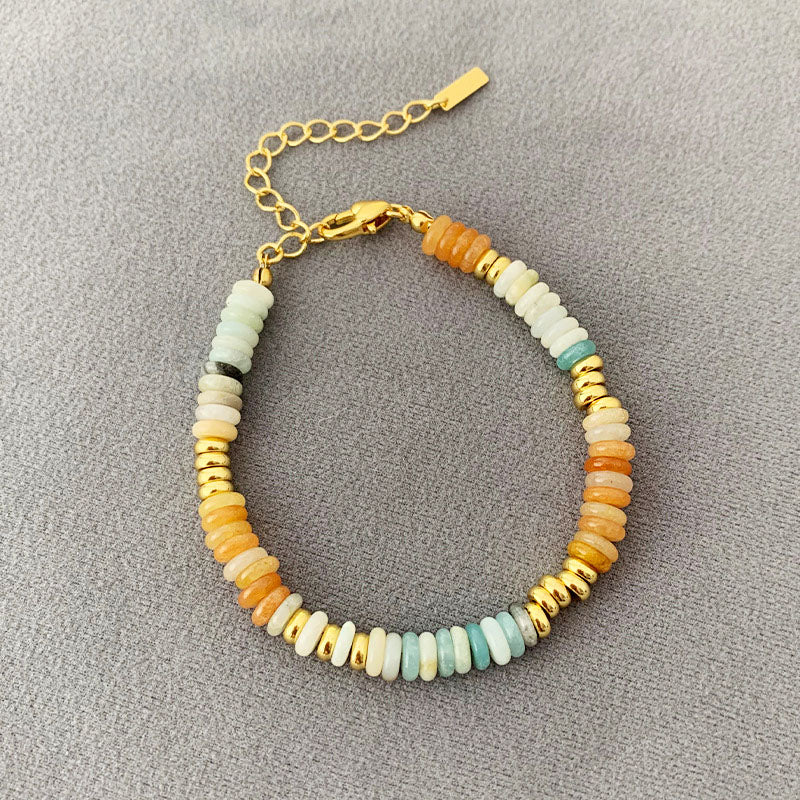 A vibrant set of five stackable bohemian bracelets featuring multicolor natural stone beads and gold accents, arranged on a white surface.