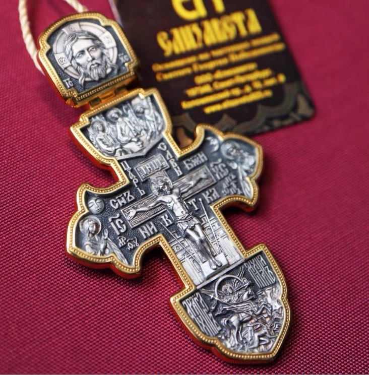 Detailed view of a custom ornate silver crucifix pendant, a type of Orthodox cross Catholic necklace, showcasing intricate religious engravings.
