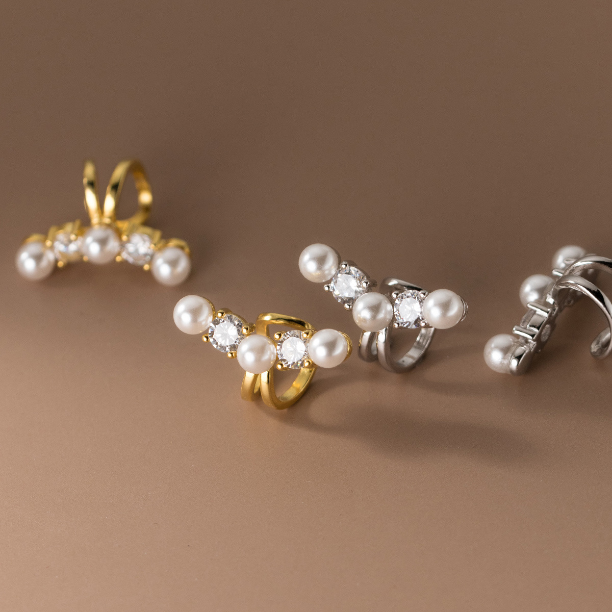 A collection of 925 sterling silver non-pierced ear cuffs in both gold and silver finishes, featuring elegant pearls and sparkling cubic zirconia.