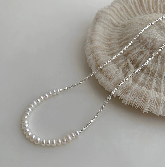 A close-up product shot of the 925 sterling silver necklace featuring freshwater pearls and a delicate silver chain with a lobster clasp.