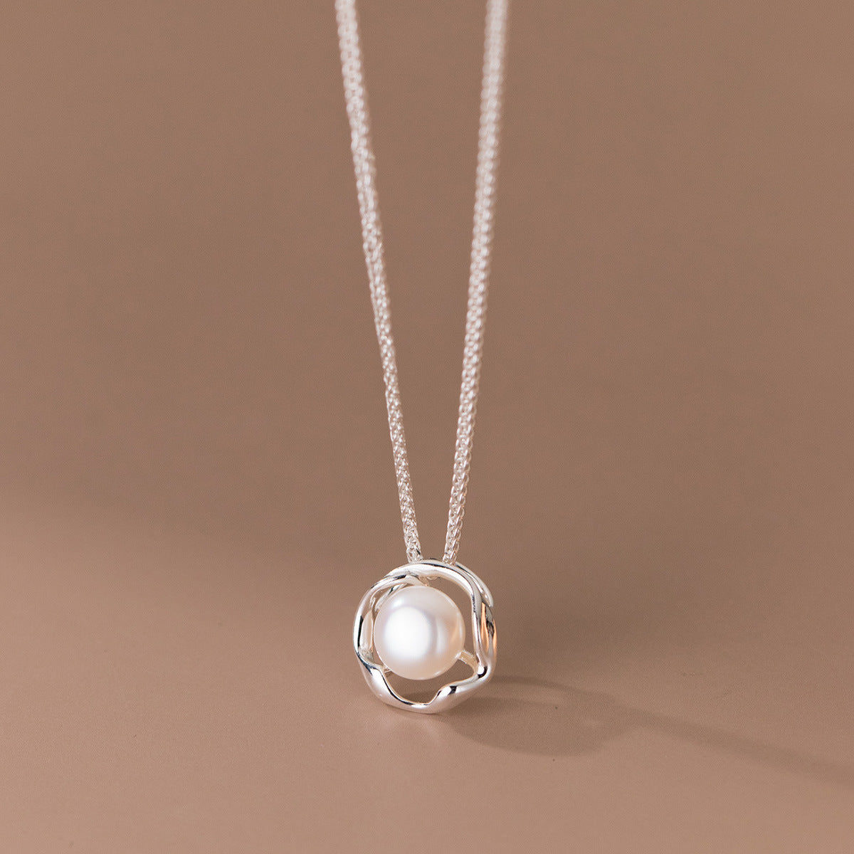 A delicate 925 sterling silver necklace featuring a single, elegant pearl pendant, displayed on a neutral background.